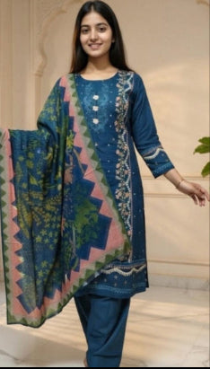 Woman in a blue traditional outfit standing in an elegant interior setting