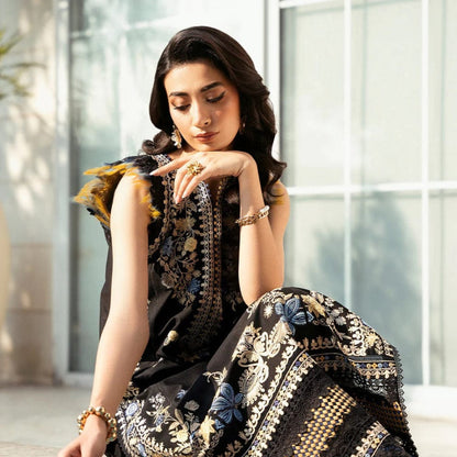 Woman in a black and gold traditional outfit sitting by a pool.